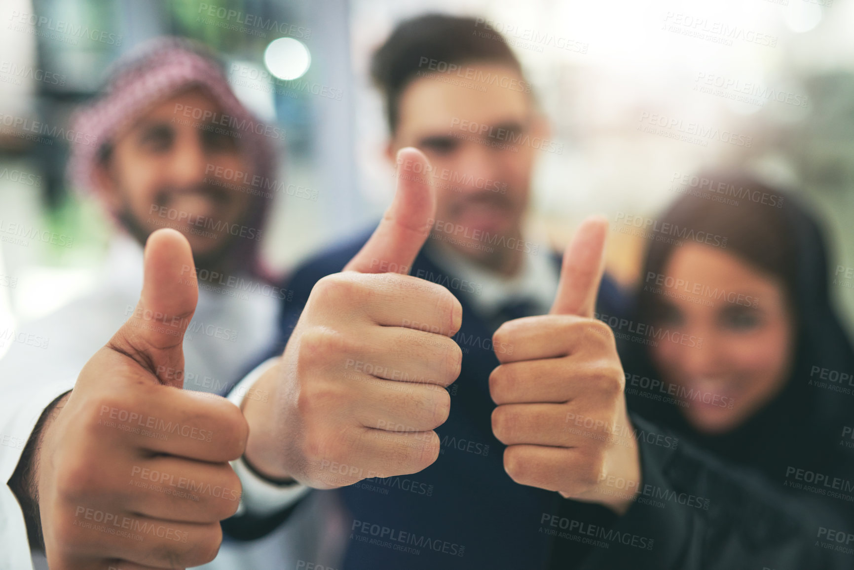 Buy stock photo Portrait of a team of colleagues showing thumbs up in an arabic office