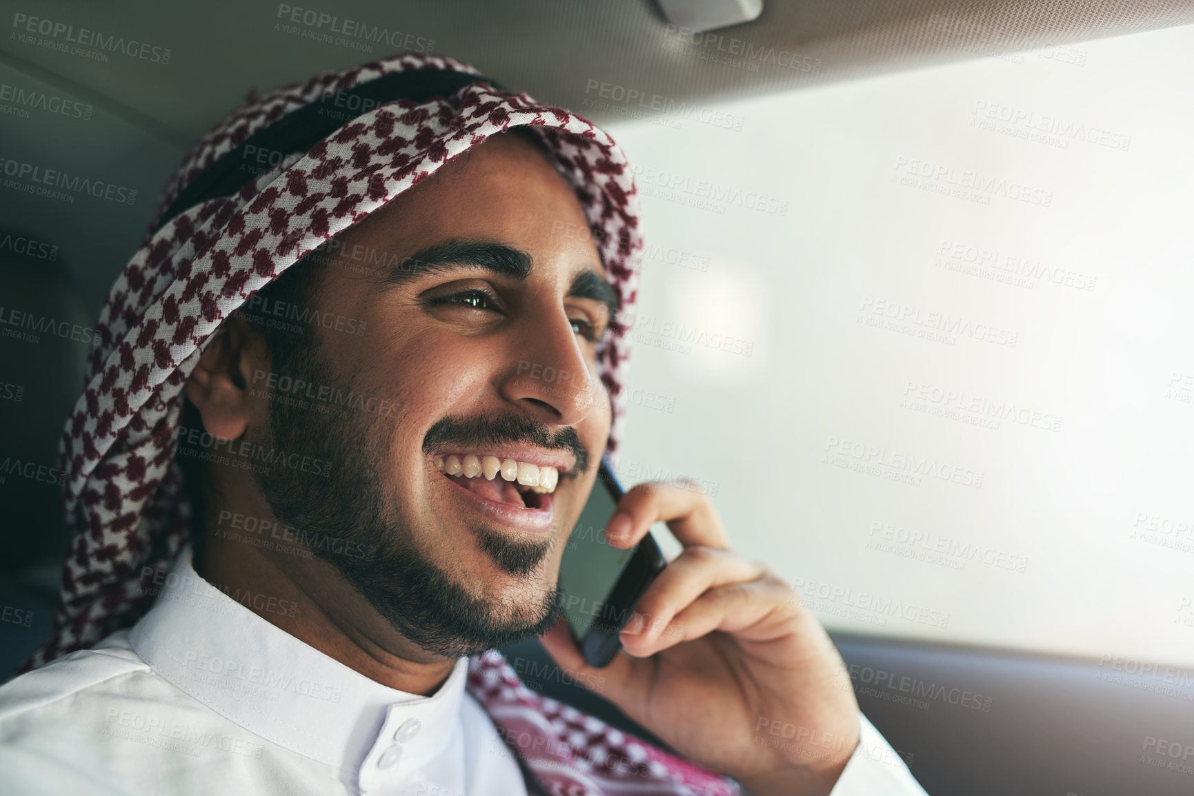 Buy stock photo Shot of a young muslim businessman using his phone while traveling in a car