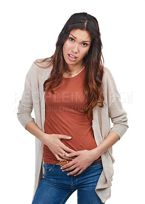 Buy stock photo Portrait of a young woman with a stomachache holding her abdomen in studio