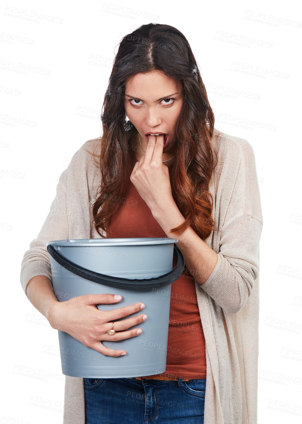 Buy stock photo Portrait of a young woman imitating nausea while holding a bucket in studio