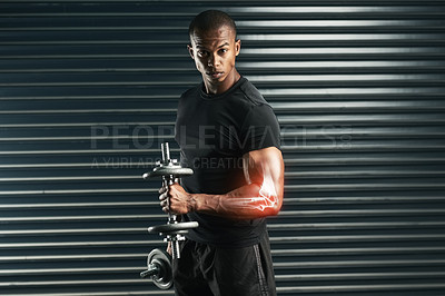 Buy stock photo Cropped portrait of an athletic young man working out with a dumbbell in the studio
