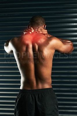 Buy stock photo Rearview shot of an athletic young man holding his neck in pain during a workout