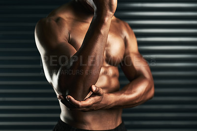 Buy stock photo Studio shot of an unrecognizable man examining an elbow injury during his workout