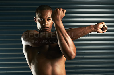 Buy stock photo Cropped portrait of an athletic young man going through his warmup routine in the studio