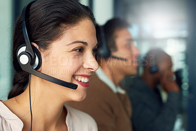 Buy stock photo Cropped shot of a call centre agent working in an office with her colleagues in the background