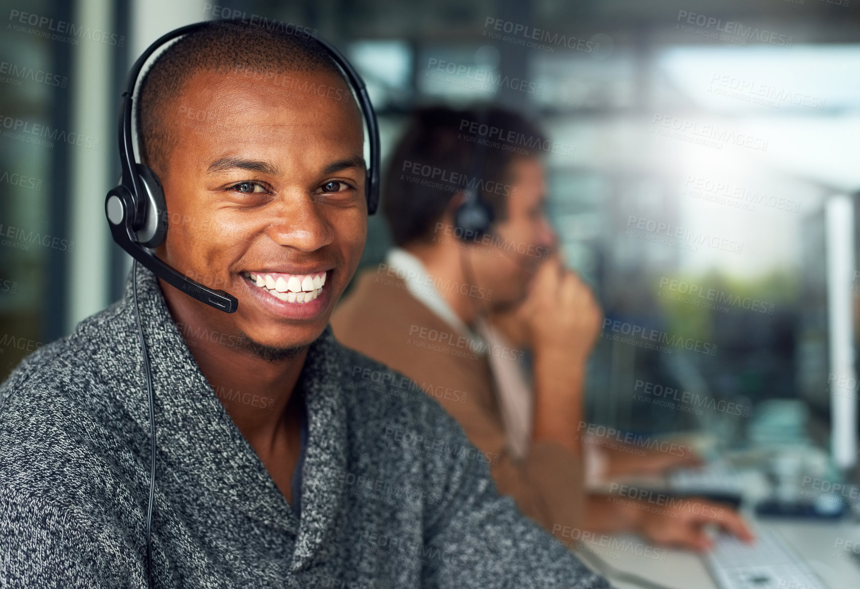 Buy stock photo Portrait of a call centre agent working in an office with his colleagues in the background