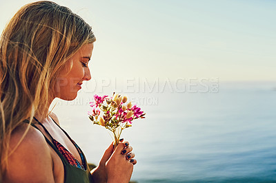 Buy stock photo Shot of a happy young woman holding a bunch of flowers while standing outside