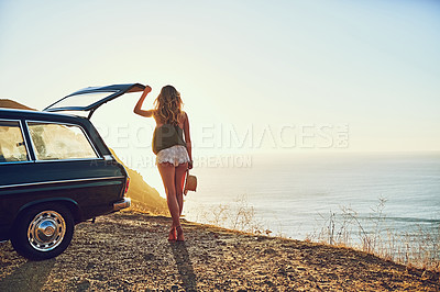 Buy stock photo Rearview shot of a young woman standing next to her car during a roadtrip