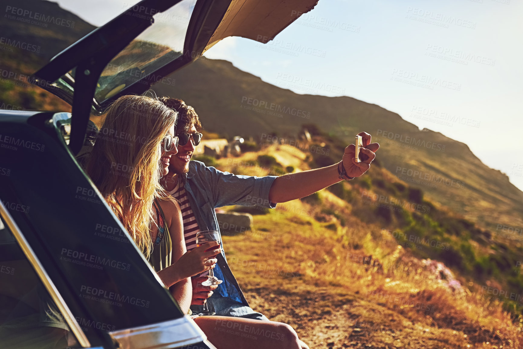 Buy stock photo Couple, car and sunset for road trip with selfie, adventure and freedom for transport together. Vehicle, memories or social media for happiness in California, vacation and love  for honeymoon picture