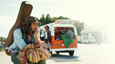 Buy stock photo Shot of a young man with a guitar on his back sitting at the side of the road with his girlfriend and van in the background