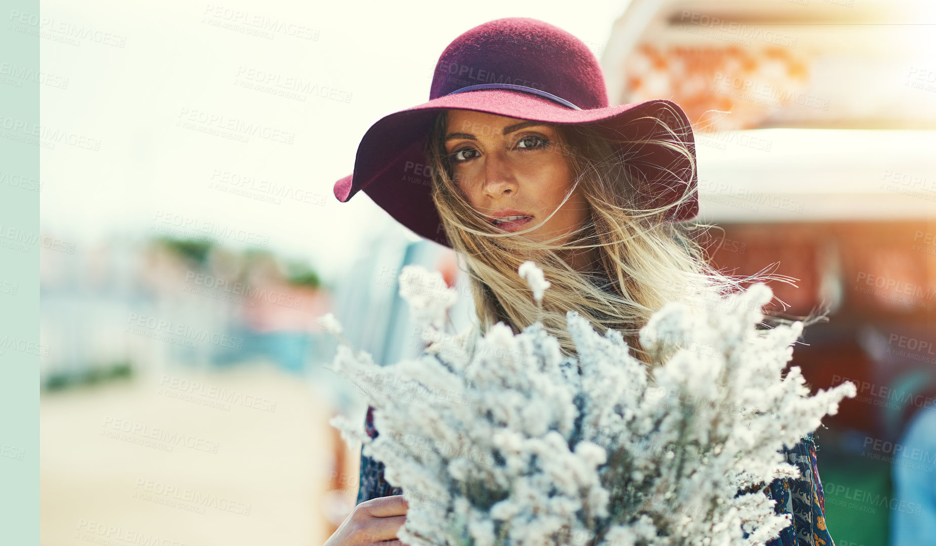 Buy stock photo Portrait of a young woman standing outside with a bouquet of wildflowers