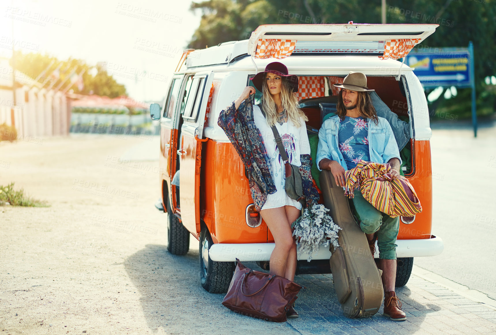 Buy stock photo Shot of a young hipster woman hitchhiking at the side of the road with her broken down van in the background