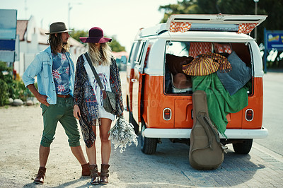 Buy stock photo Shot of young hipster couple standing outside next to a camper van