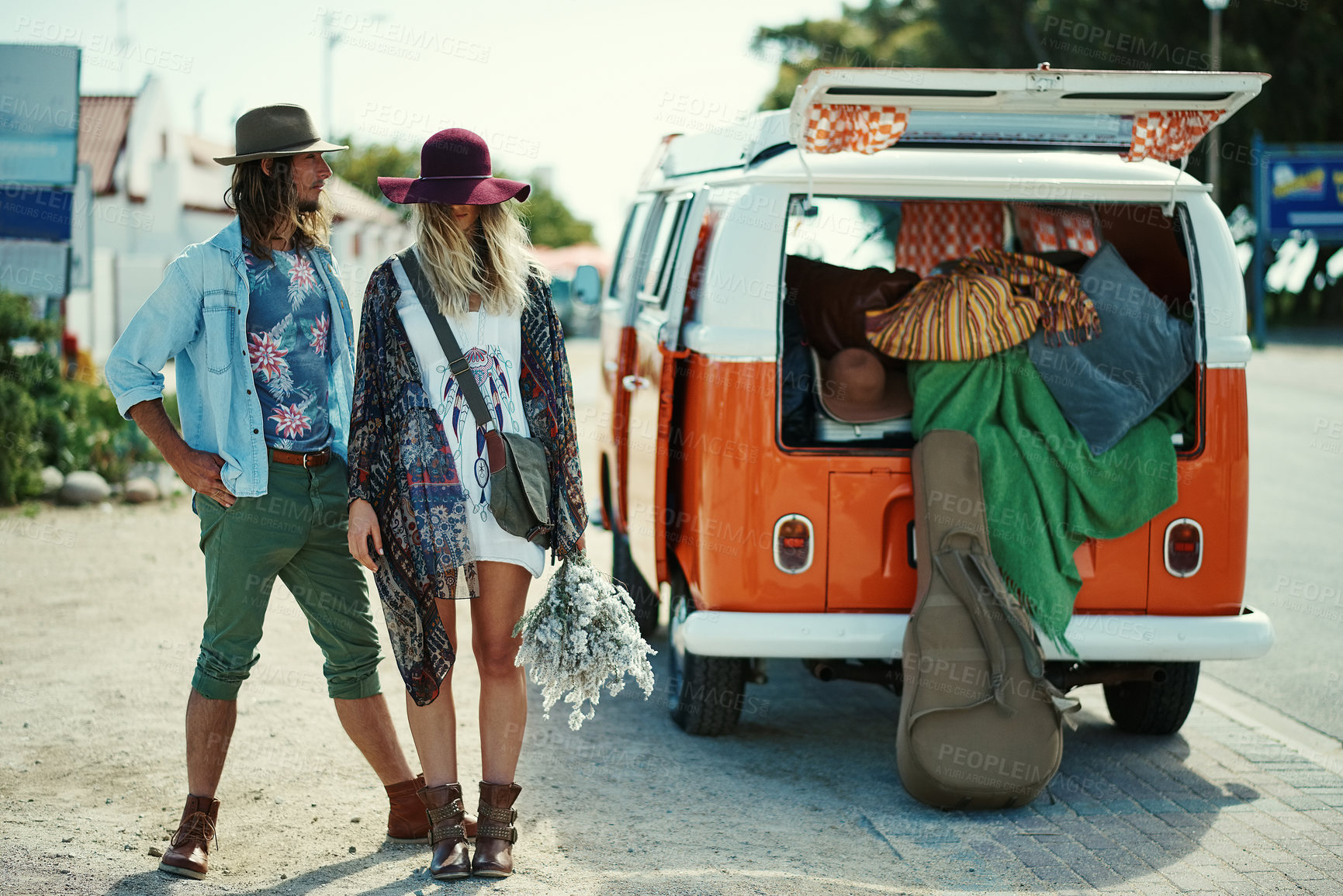 Buy stock photo Shot of young hipster couple standing outside next to a camper van
