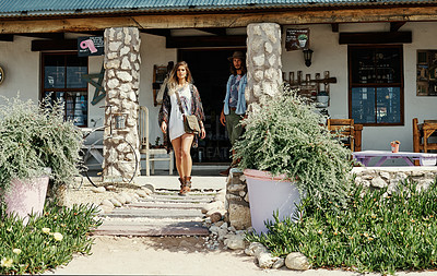 Buy stock photo Shot of a young hipster couple walking out of a cafe