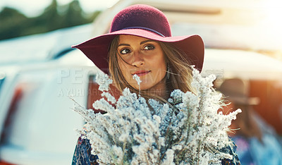 Buy stock photo Shot of a young woman standing outside with a bouquet of wildflowers