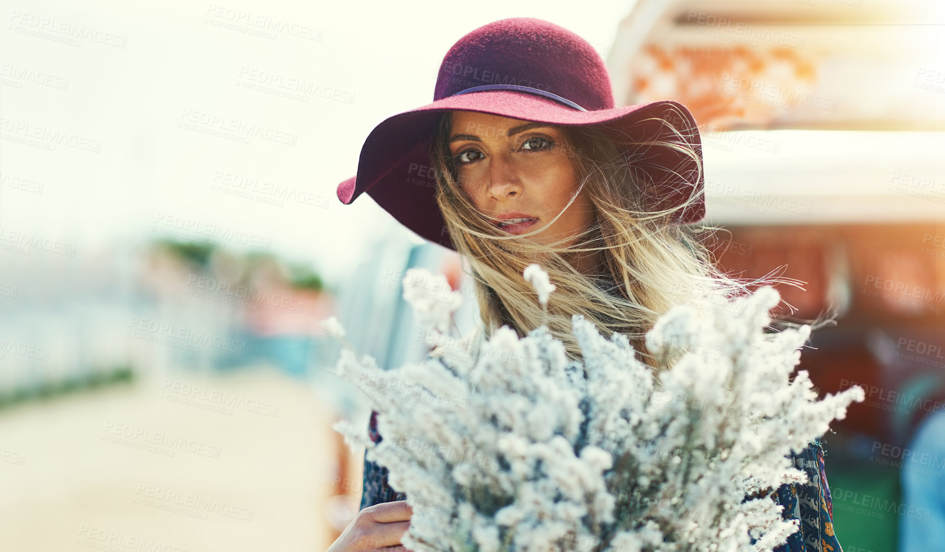 Buy stock photo Portrait of a young woman standing outside with a bouquet of wildflowers