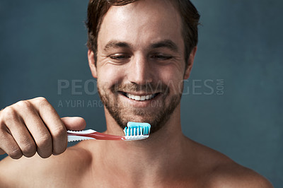Buy stock photo Cropped shot of a handsome young man brushing his teeth against a grey background