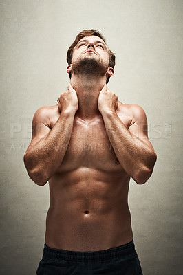 Buy stock photo Shot of a handsome and muscular young man posing shirtless in the studio