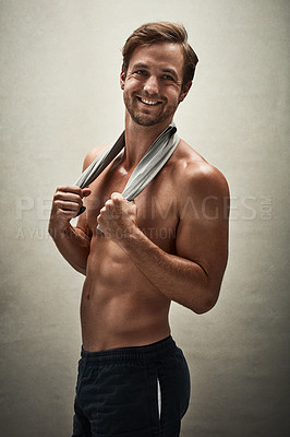 Buy stock photo Shot of a handsome and muscular young man posing shirtless in the studio
