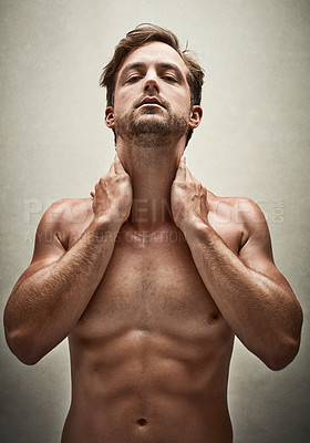 Buy stock photo Shot of a handsome and muscular young man posing shirtless in the studio