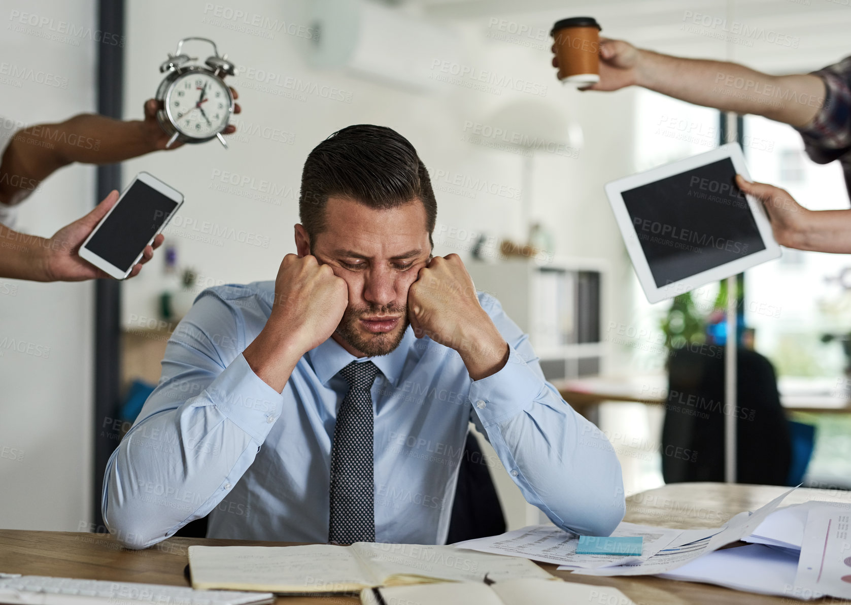 Buy stock photo Shot of a stressed out businessman surrounded by demanding colleagues in an office