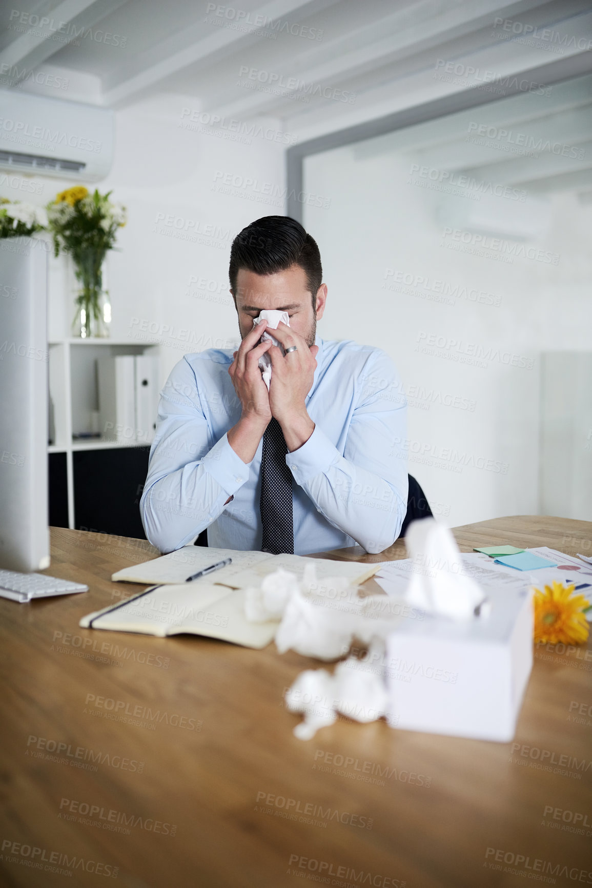Buy stock photo Shot of a young businessman suffering with allergies at work