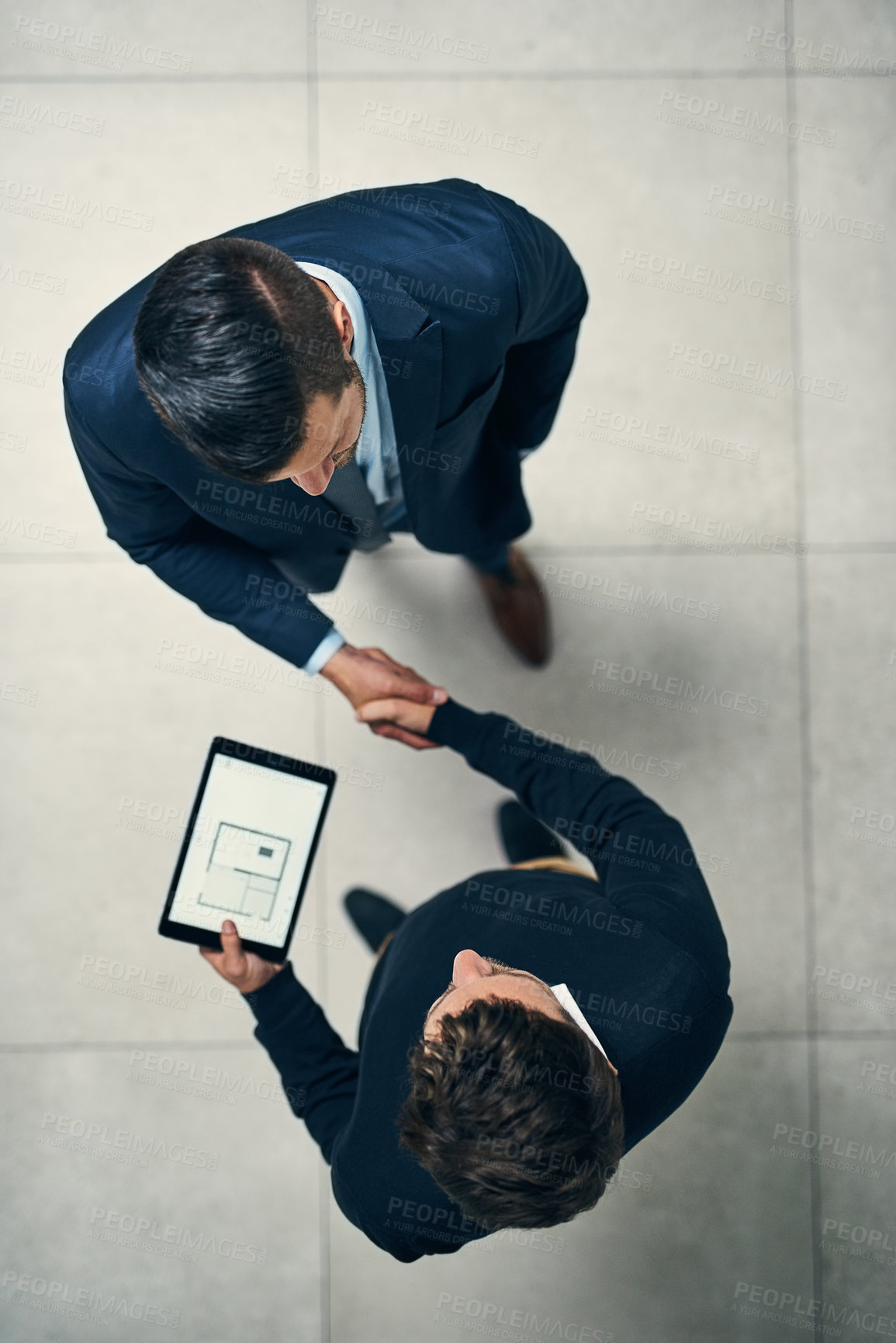 Buy stock photo High angle shot of two businessmen shaking hands in an office