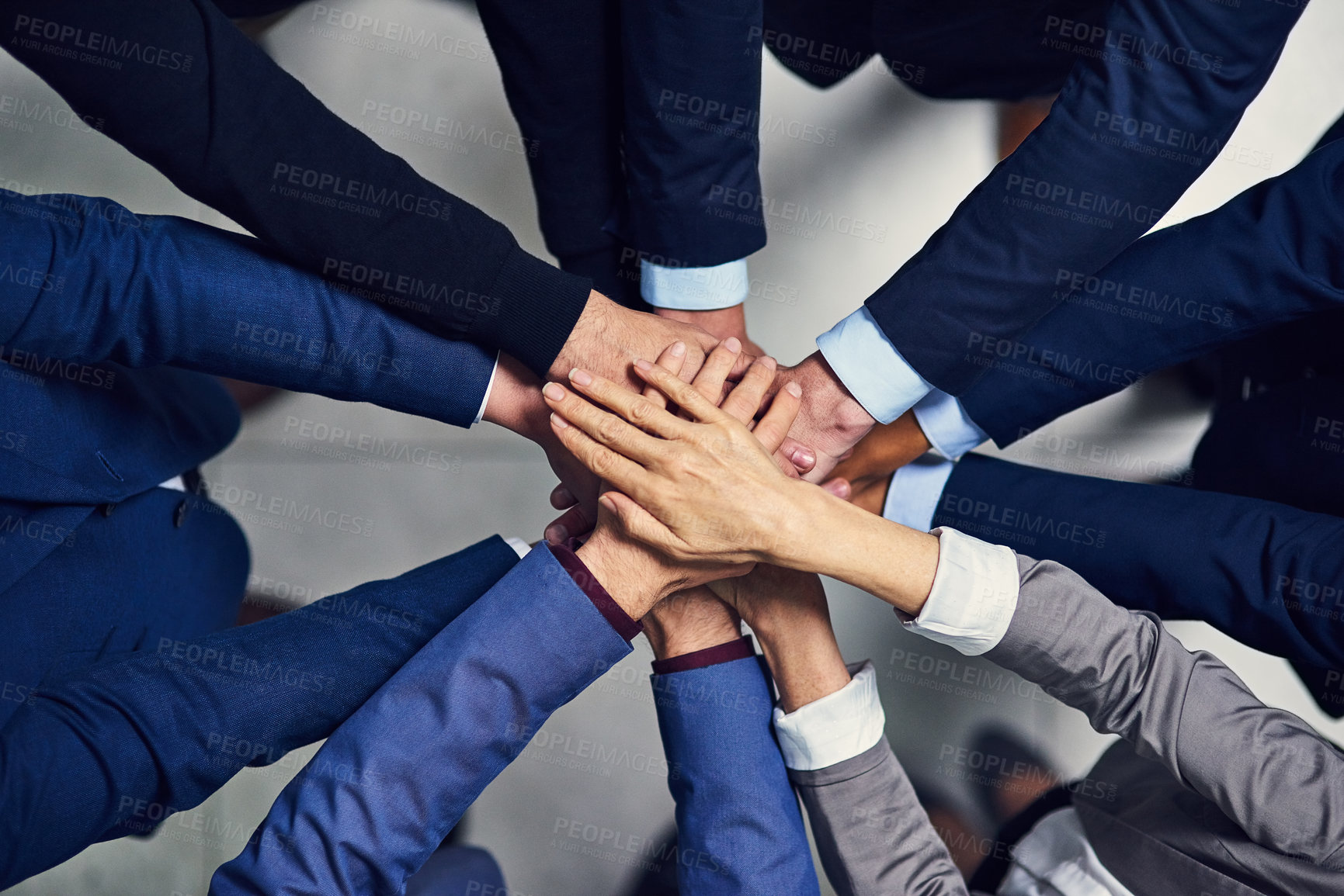 Buy stock photo High angle shot of a group of businesspeople joining their hands together in unity
