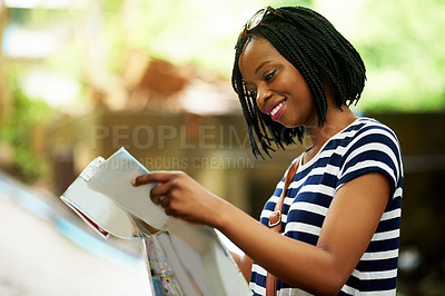 Buy stock photo Shot of a smiling young woman reading a map while traveling in Thailand