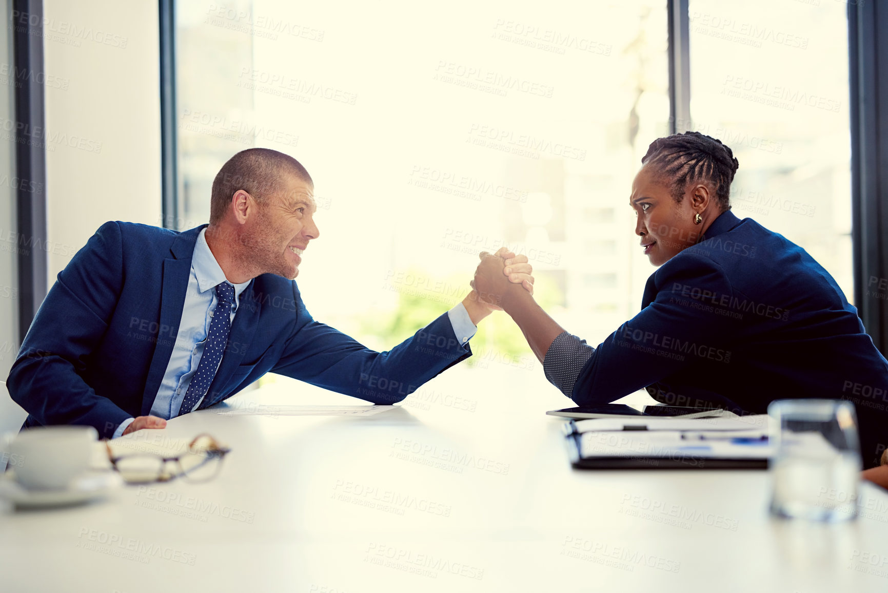 Buy stock photo Shot of two businesspeople arm wrestling in an office