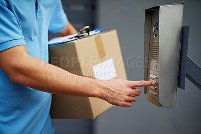 Buy stock photo Closeup shot of a courier ringing an intercom while making a delivery