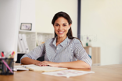 Buy stock photo Portrait of a confident young businesswoman sitting at her desk in an office