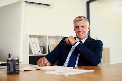 Buy stock photo Portrait of a confident mature businessman sitting at his desk in an office