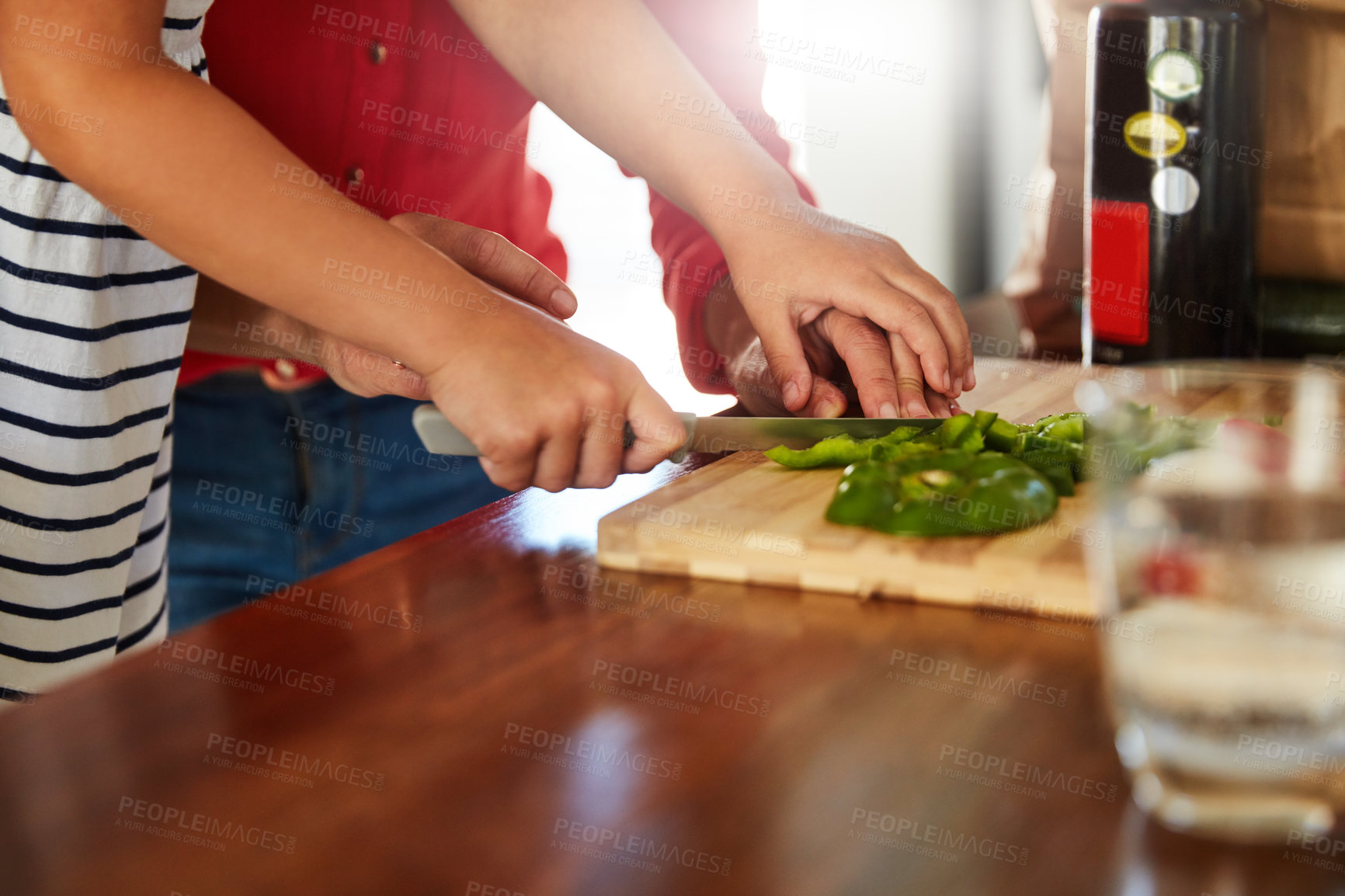 Buy stock photo Shot of an unidentifiable mother helping her little girl chop vegetables in the kitchen