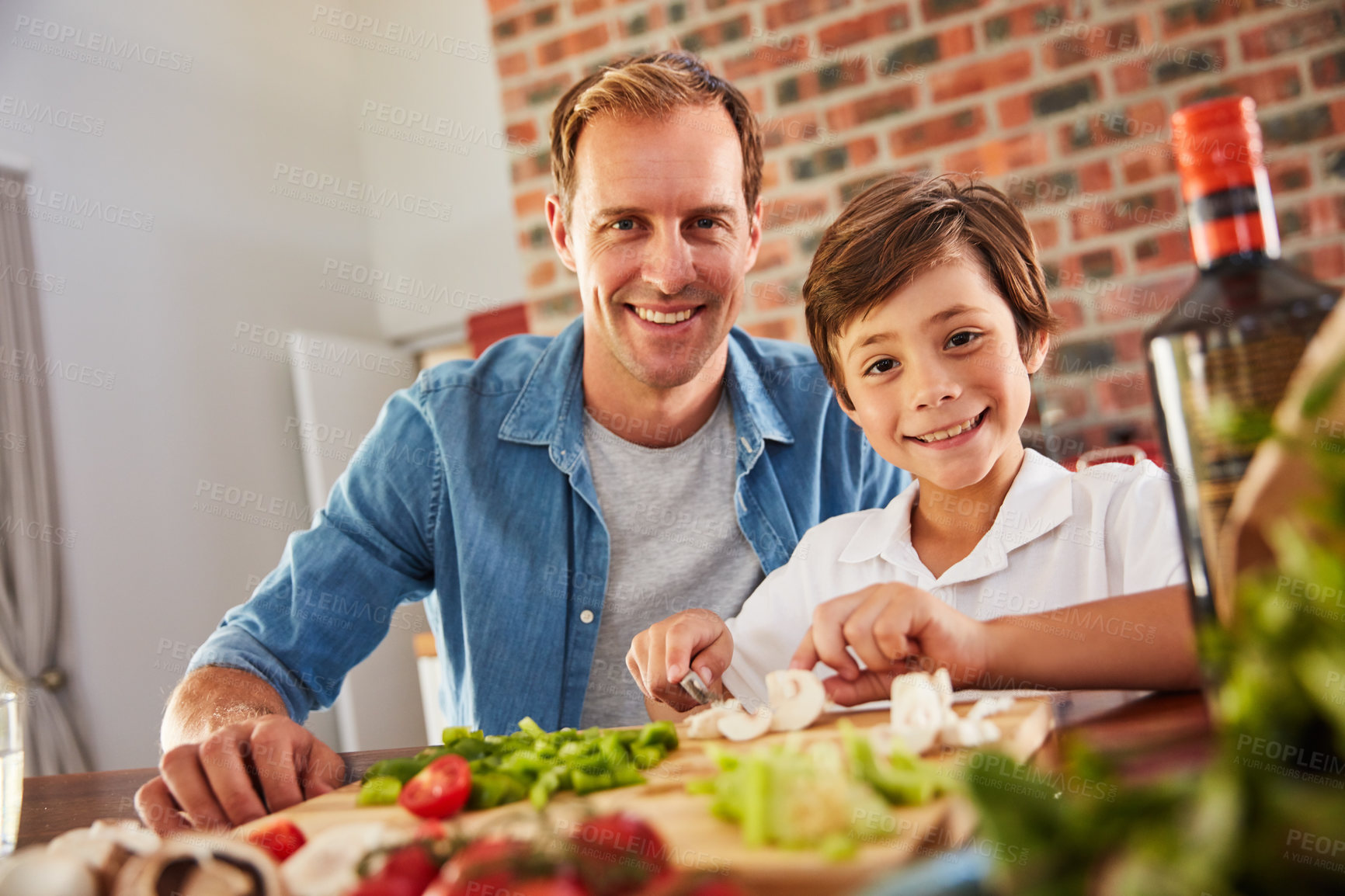 Buy stock photo Portrait of a father and his little boy chopping vegetables in the kitchen