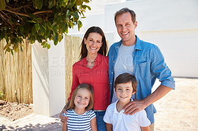 Buy stock photo Portrait of smiling parents and their young son and daughter standing outside in their yard on a sunny day