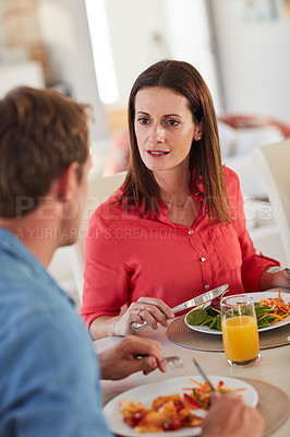 Buy stock photo Shot of an angry woman confronting her husband over something at lunch