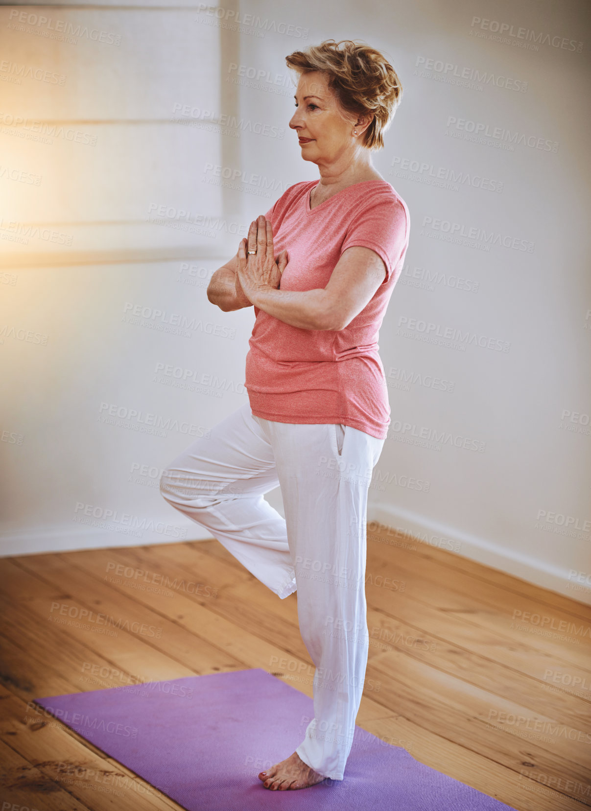 Buy stock photo Shot of a senior woman doing yoga alone