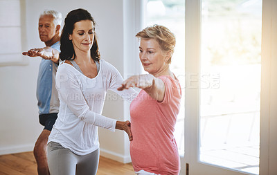 Buy stock photo Shot of a teacher helping a senior woman during a yoga class