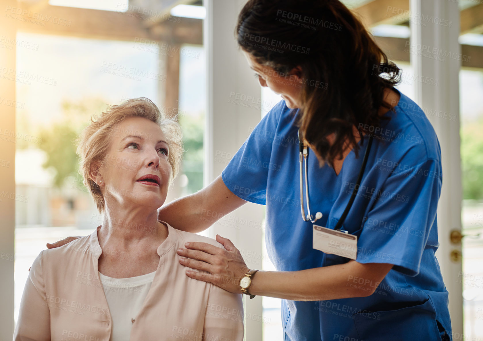 Buy stock photo Shot of a senior woman talking with a nurse in assisted living facility
