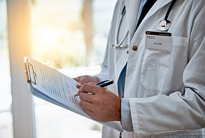 Buy stock photo Closeup shot of a doctor holding a clipboard reading a medical chart
