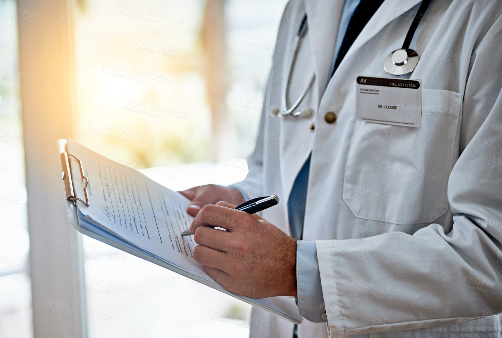 Buy stock photo Closeup shot of a doctor holding a clipboard reading a medical chart