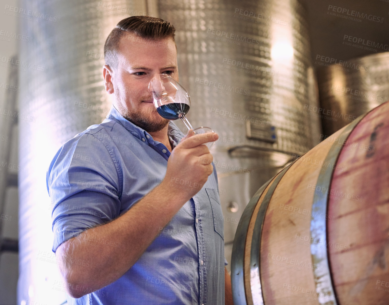 Buy stock photo Cropped shot of a man enjoying wine tasting in his distillery