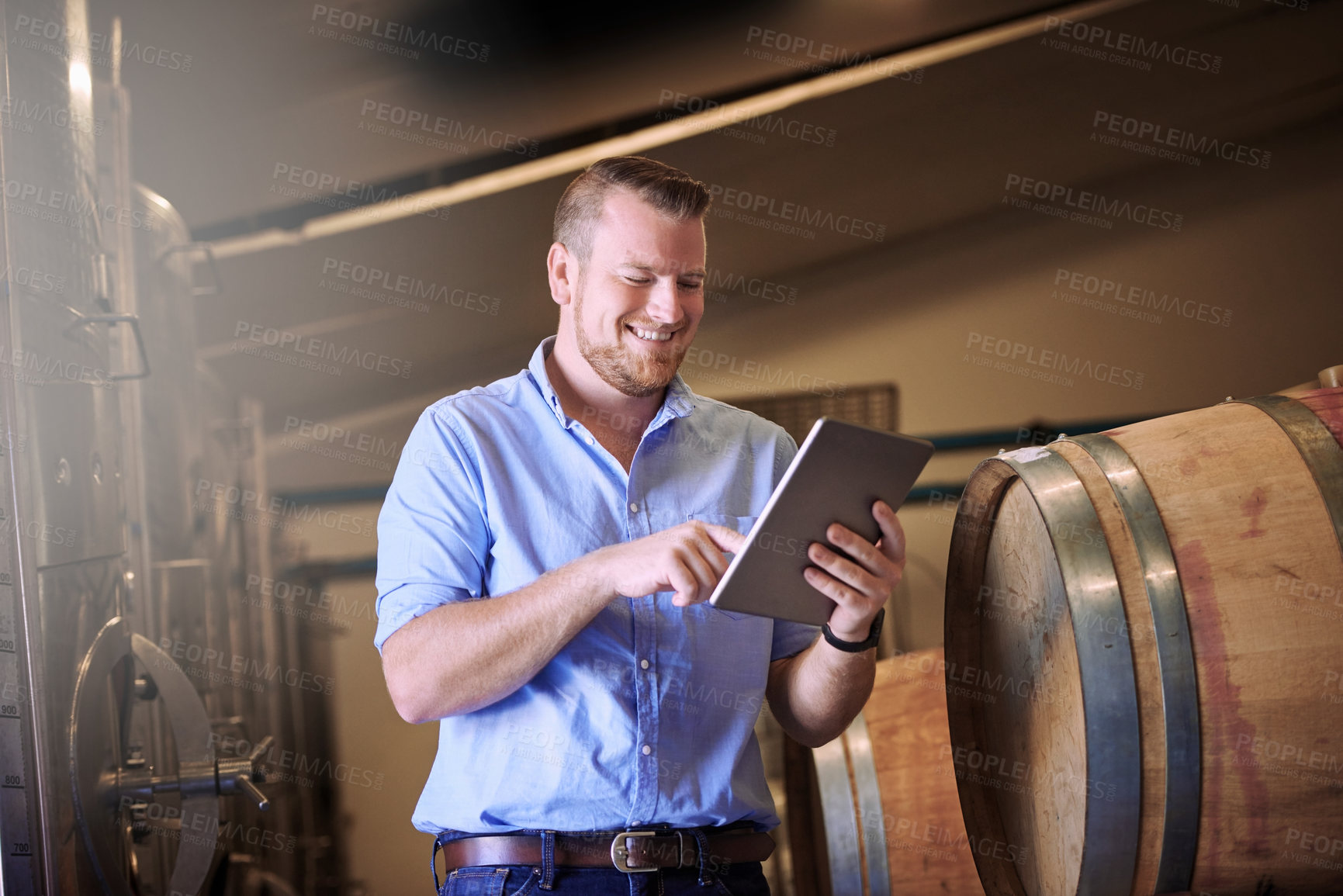 Buy stock photo Business, man and smile with tablet in brewery as manager with pride on product, process or schedule for supplier. Employee, barrel and happy for beer production, manufacturing or craft in factory