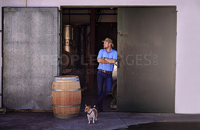 Buy stock photo Shot of a male sommelier standing in the doorway of his distillery