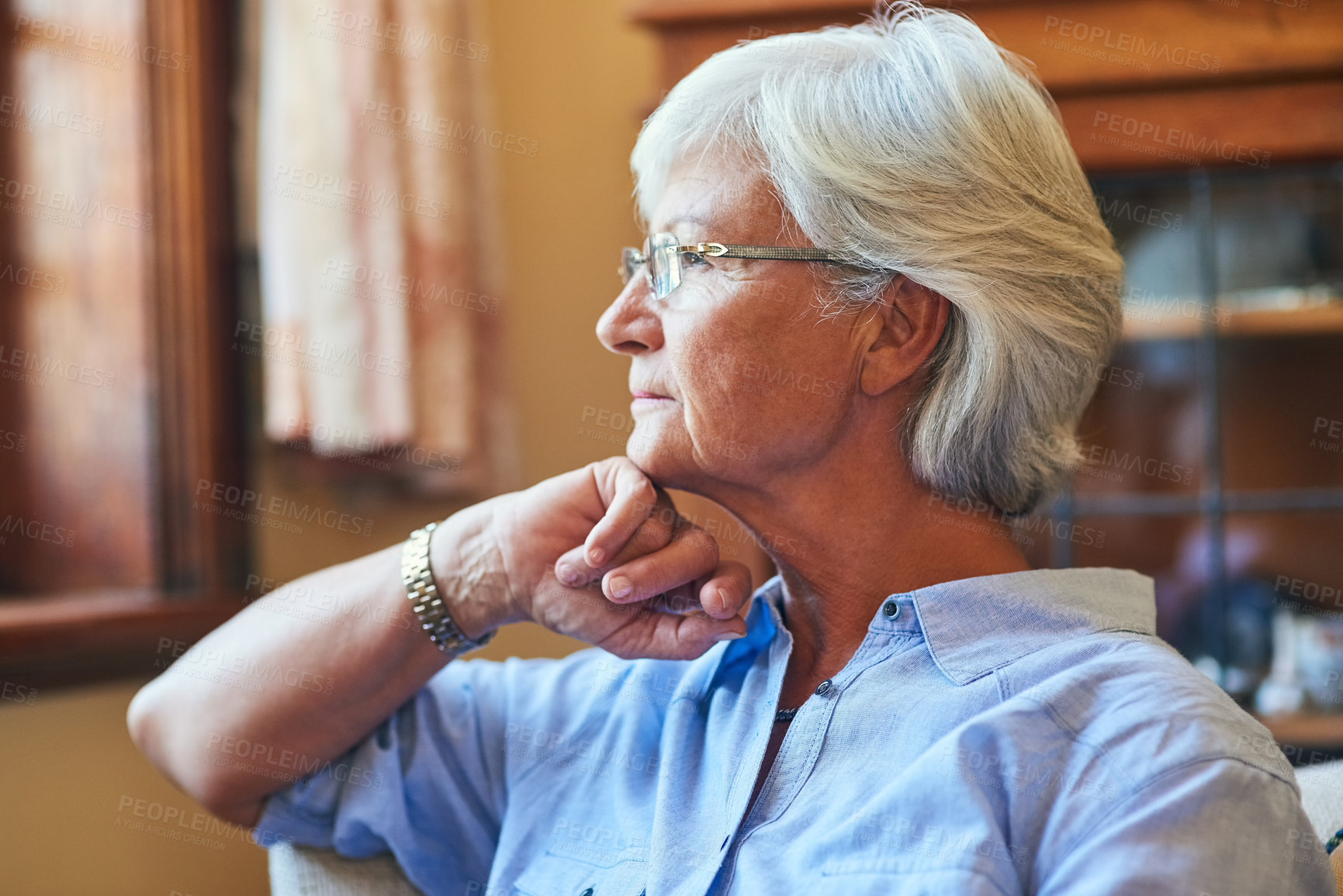 Buy stock photo Cropped shot of a senior woman looking thoughtful at home