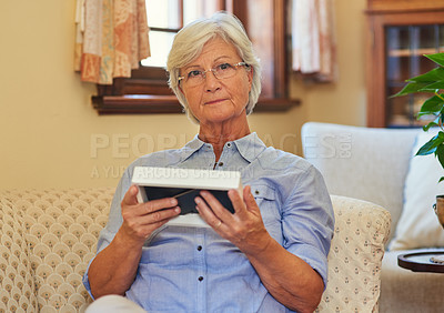 Buy stock photo Portrait of a senior woman holding a photo frame at home