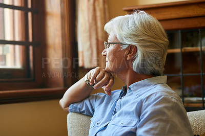 Buy stock photo Cropped shot of a senior woman looking out the window at home