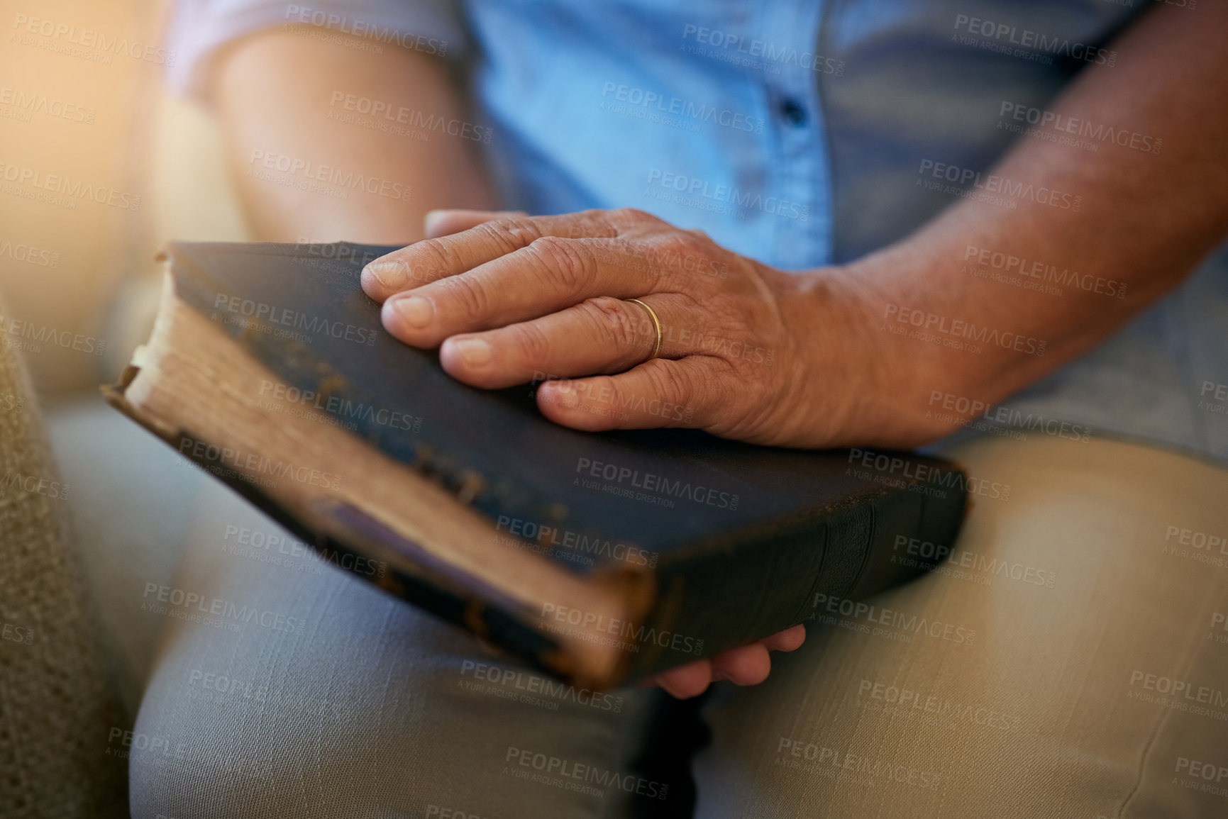 Buy stock photo Closeup shot of a senior woman holding a Bible at home